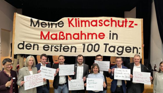 Die OB-Kandidaten stehen vor einem Banner "Meine Klimaschutzmasßnahme in den ersten 100 Tagen"